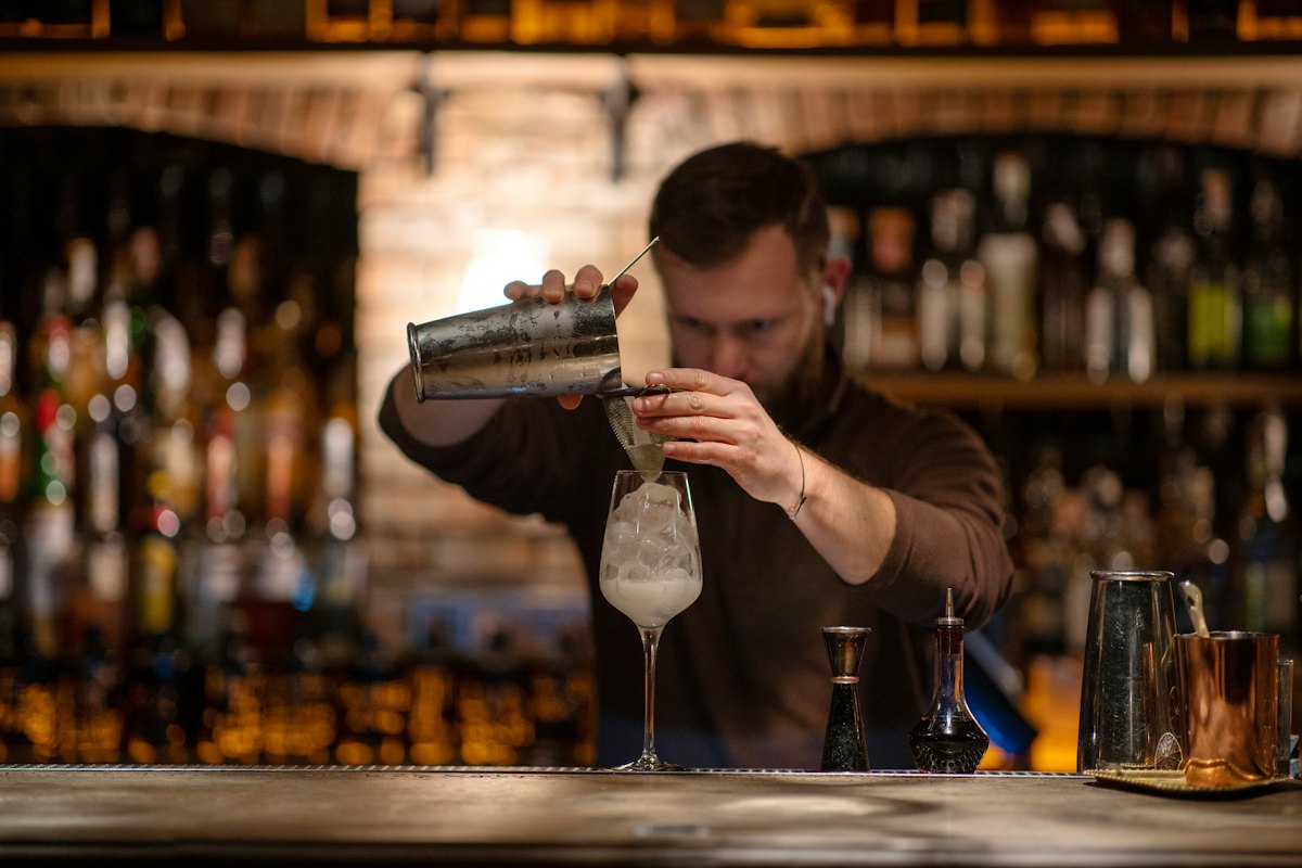 Barman che prepara un cocktail al bancone